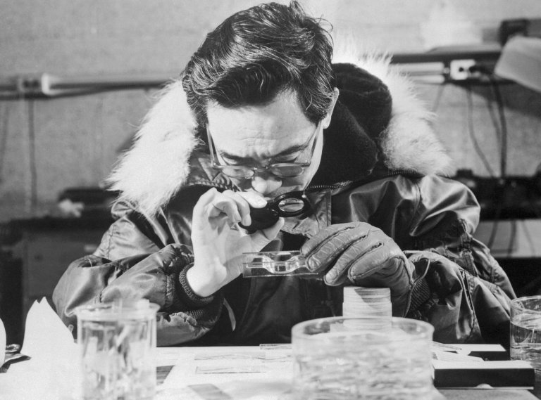 Arctic researcher studying permafrost samples for viruses and other microbes. Image is black and white.