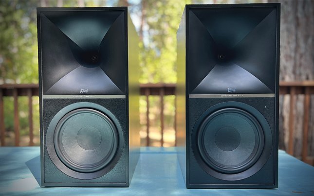 Black Klipsch the Nines powered standmount speakers sitting on a blue table.