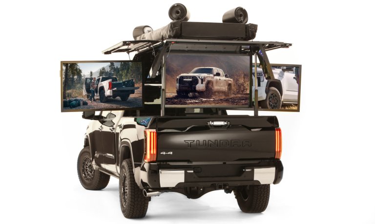 a pickup truck with three large screens in trunk