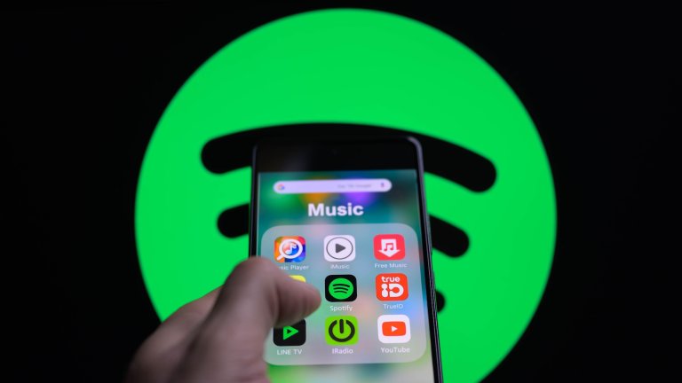 The Spotify app icon is being displayed on a smartphone with Spotify visible in the background in this photo illustration in Brussels, Belgium, on February 11, 2024. (Photo by Jonathan Raa/NurPhoto)