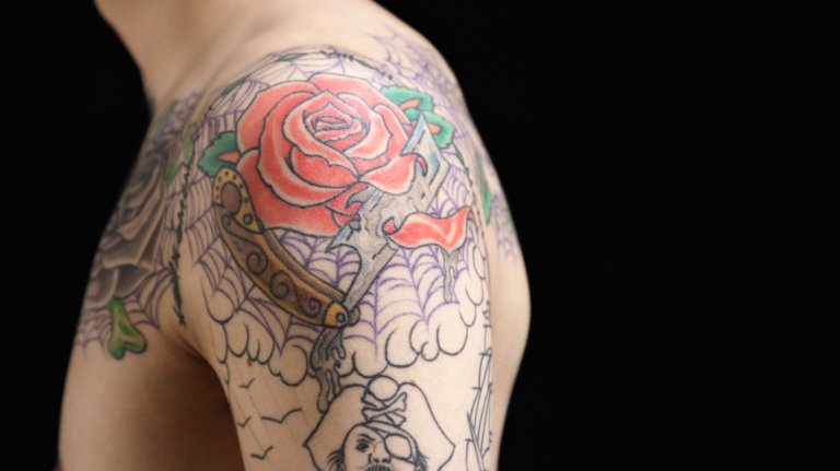 an arm covered in a rose tattoo